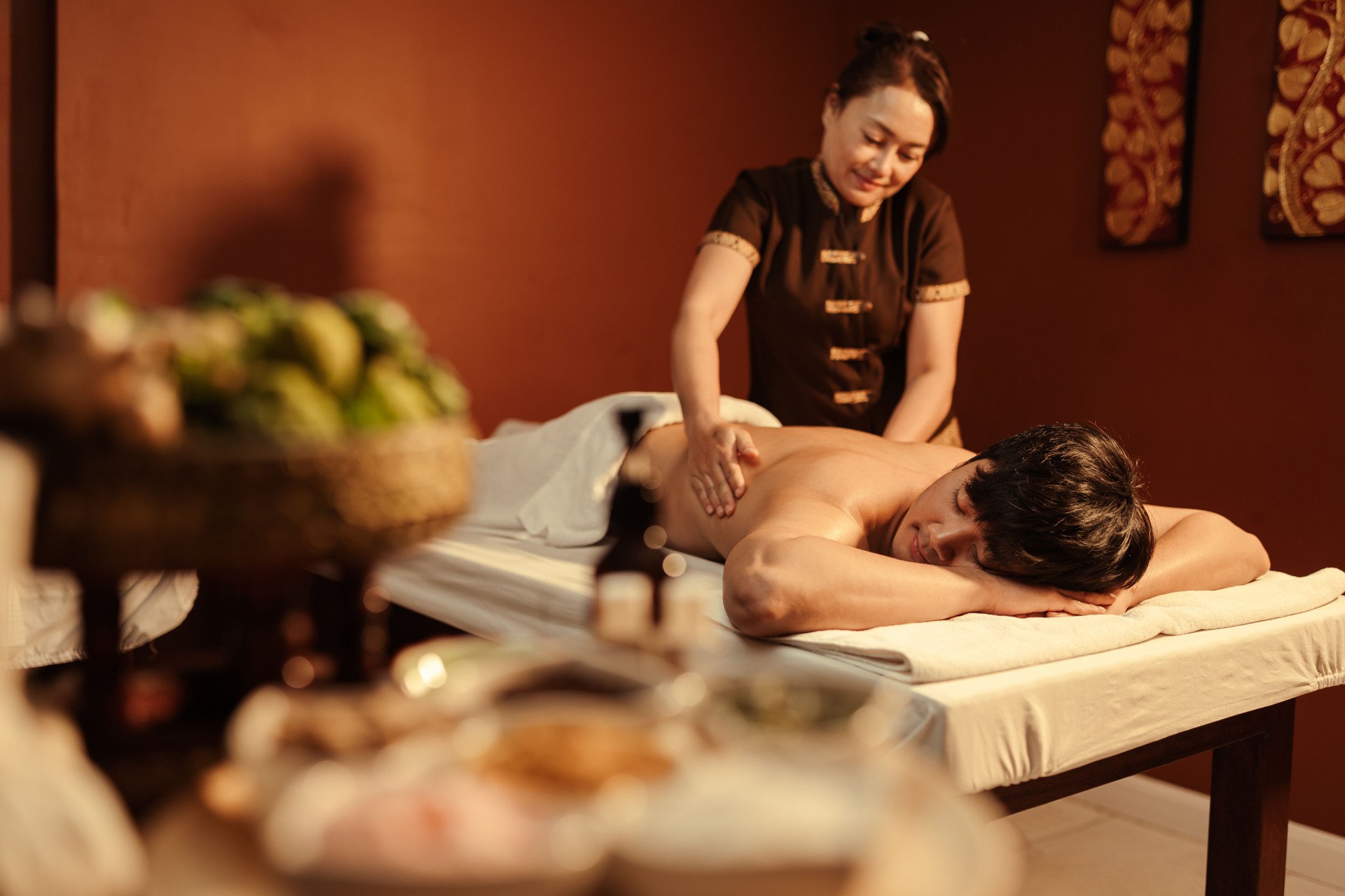 Relaxation Asian man customer get service aromatherapy massage with masseuse in spa salon.